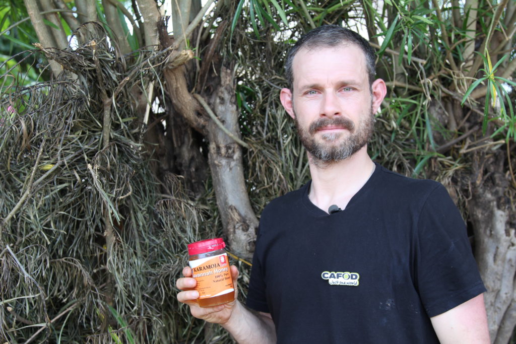 Ben with a jar of honey made by a community he met in Uganda with CAFOD