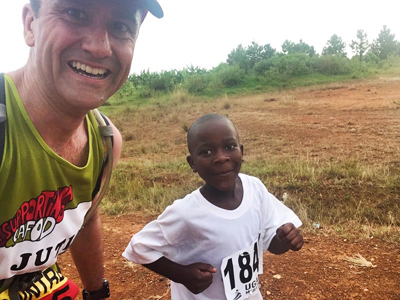 Justin runs with a local child during the Ugandan Marathon