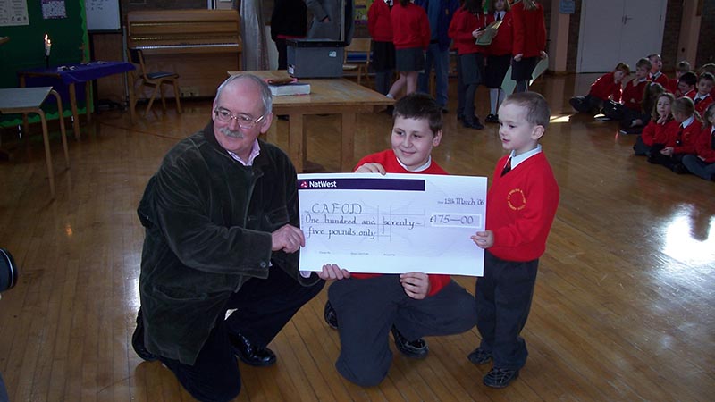 Volunteer Joe Andrew accepts a cheque from pupils at English Martyrs school in the Birmingham Diocese