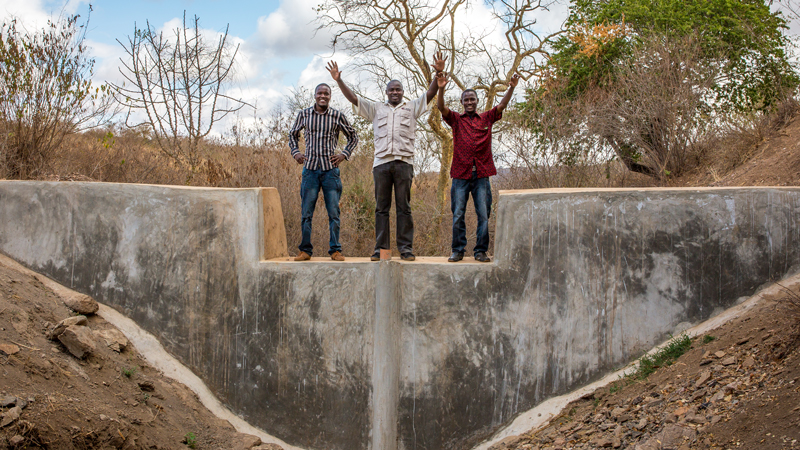 Project members celebrate on top of one of the sand dams