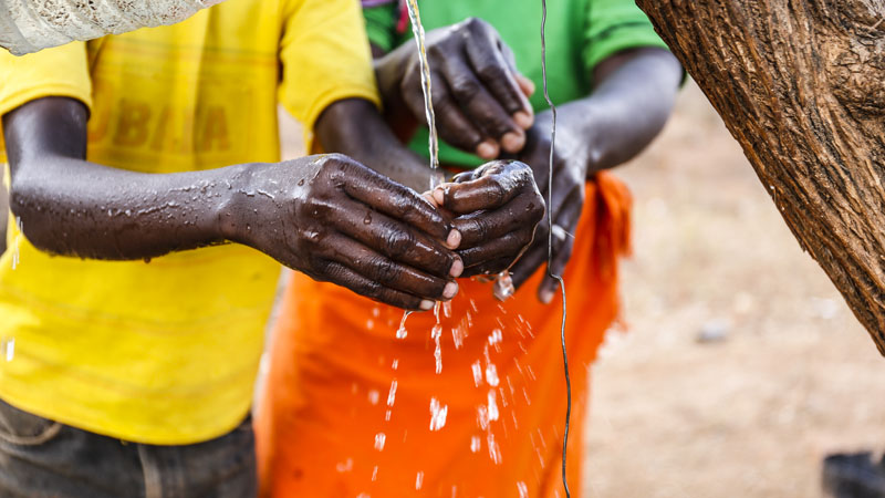 A young boy washes his hands in Musosya, Kenya