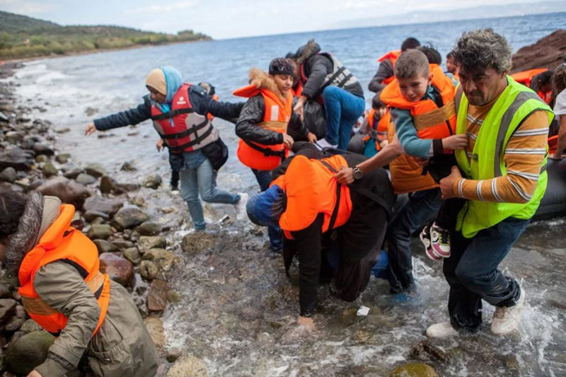 Refugees being helped ashore in Lesbos earlier this year