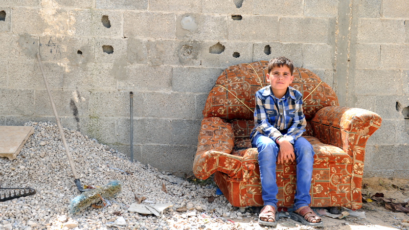 mohammed-sitting-on-a-damaged-chair-in-his-old-home-that-was-destroyed-in-the-2014-gaza-conflict