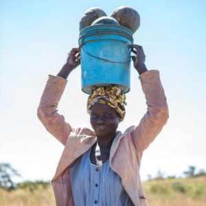 Mulenga's neighbour carrying gourds on his farm, Zambia