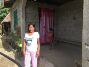 woman stood outside her new sturdier, typhoon resistant home..