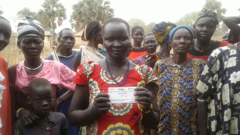 Ajok, a mother from South Sudan, holds a food voucher.