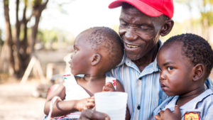 Paul Hururapwe gives his children a drink of water from the nearby reservoir.