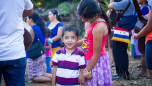 Brother and sister in El Salvador hold hands at a prayer service