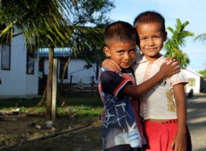 Two young boys hugging. Gifts in wills to CAFOD are vital to give children a brighter future