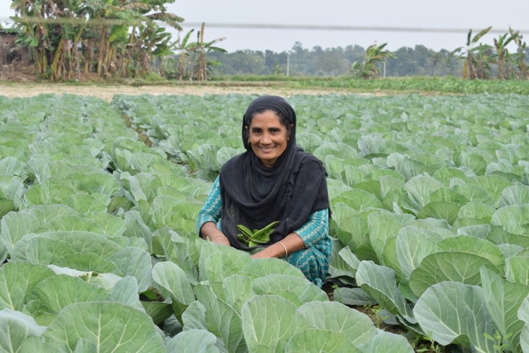 Razia Begum proudly displaying vegetables she has grown using vermi compost