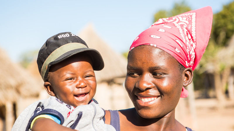 Unity and baby Twalumba smiling at each other.