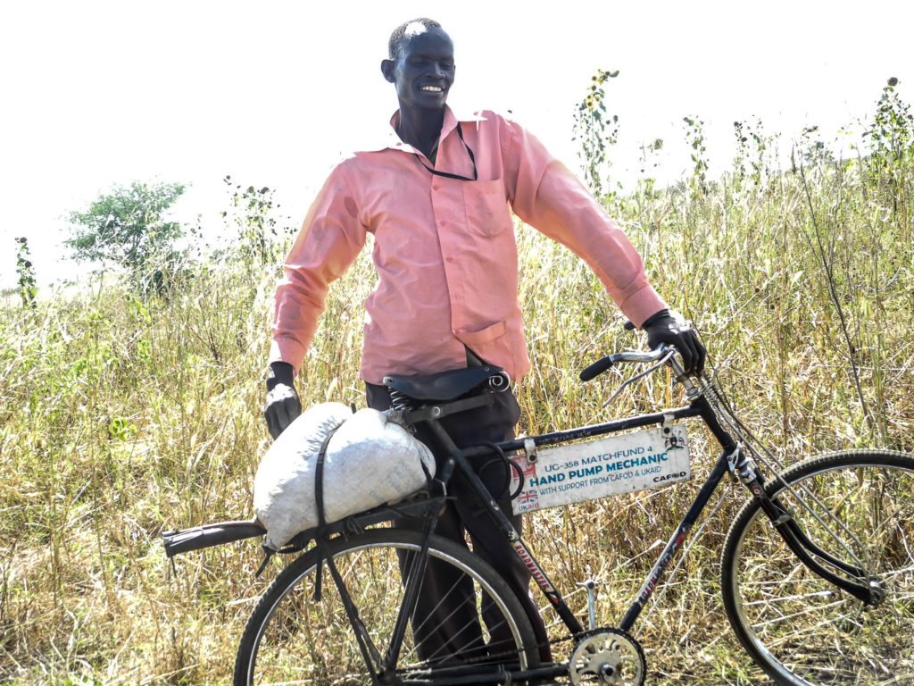 Raphael - borehole mechanic in Uganda on his CAFOD-funded bike