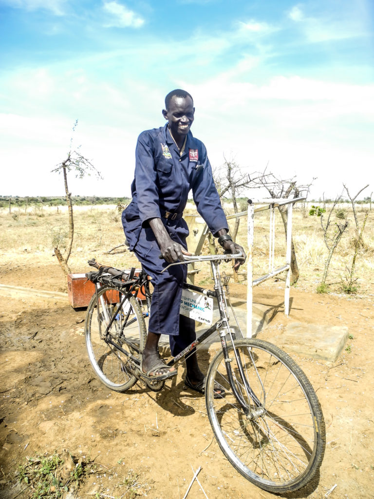 Raphael - borehole mechanic in Uganda on his CAFOD-funded bike