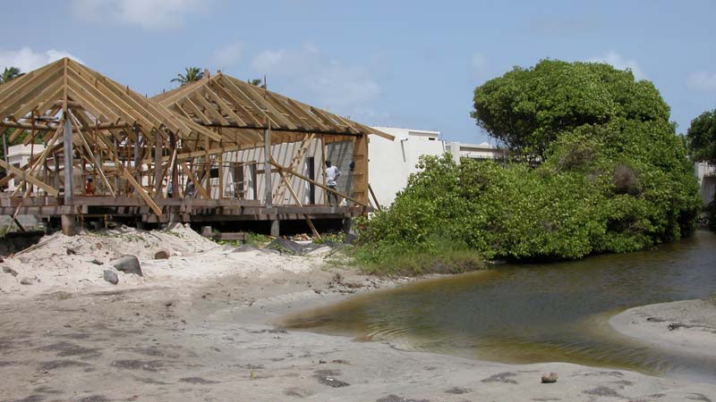 Wooden frames of houses being built next to water