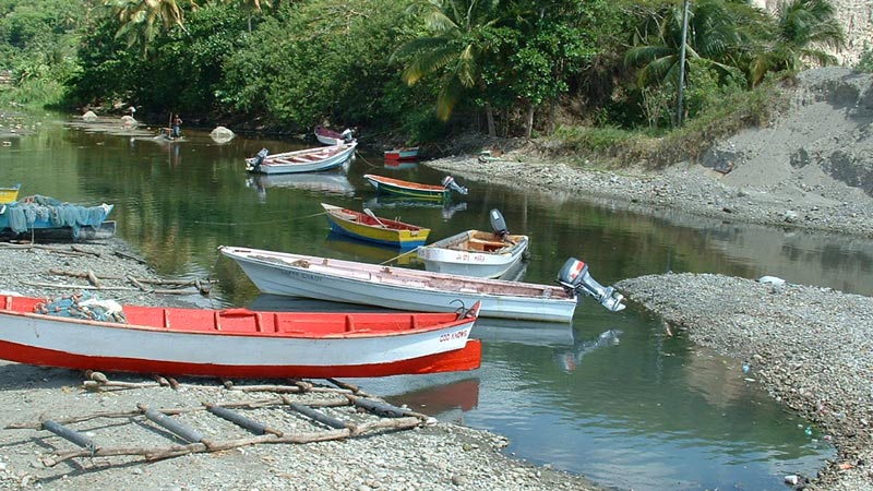 Small wooden fishing boats partially submerged in shallow water