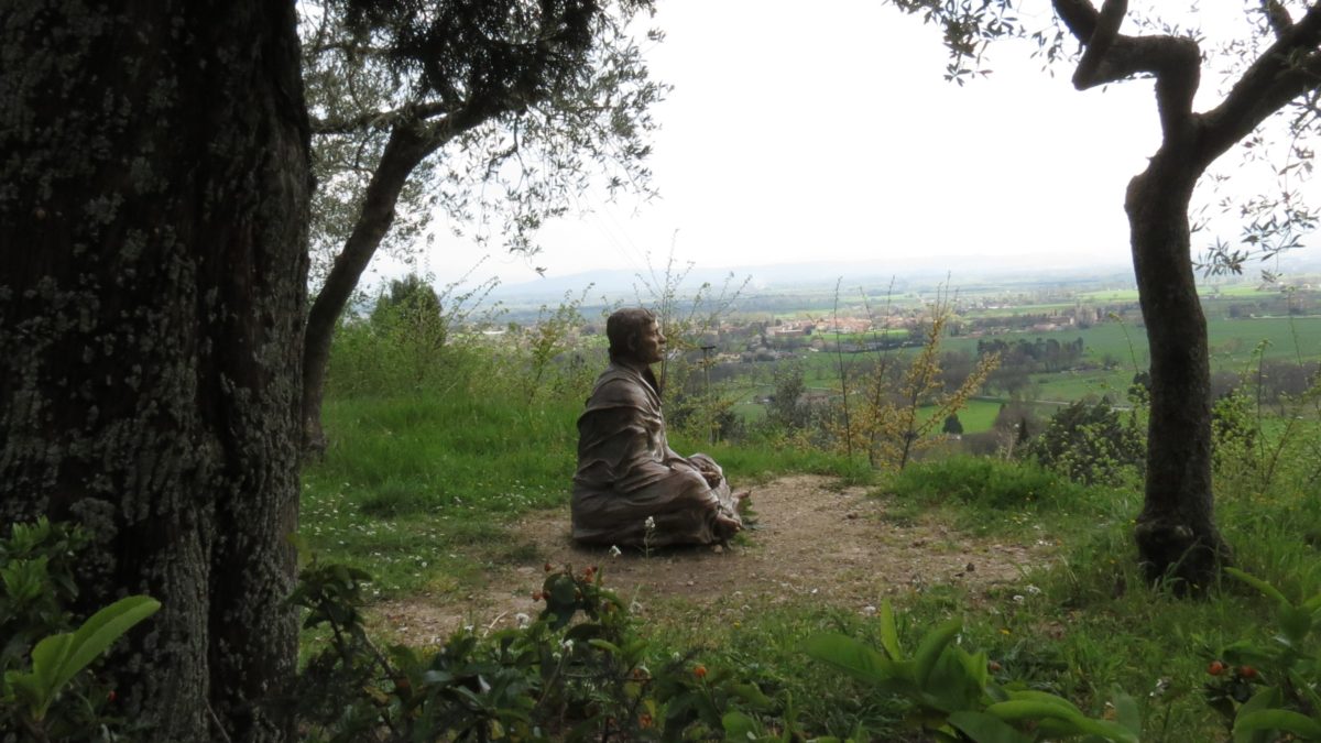 Statue of St Francis sitting looking out at creation near San Damiano, Assisi
