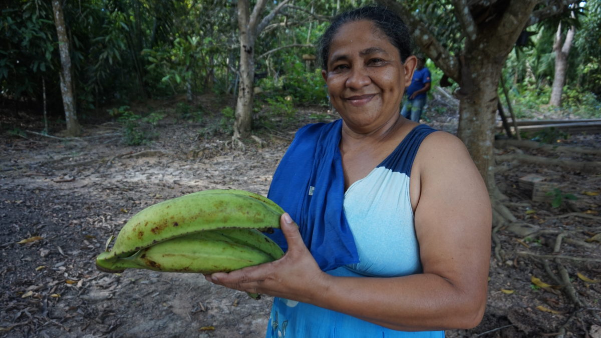 Dona Maria proudly holds her plantain grown in the Amazon rainforest without chemicals.