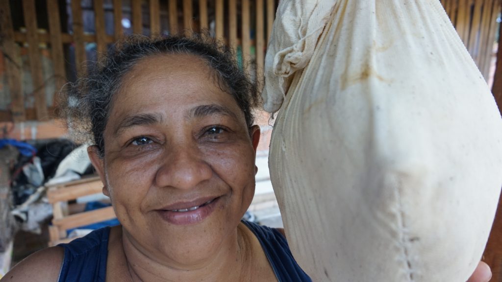 Dona Maria at home with her bag of tapioca flour.