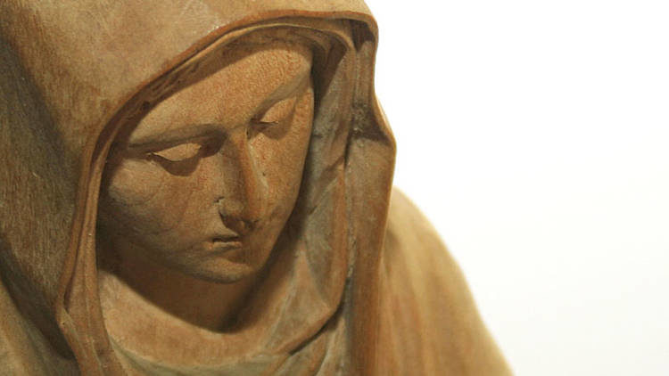 A carved wooden statue of Mary.