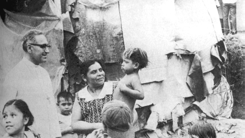 Saint Oscar Romero talking to woman and children