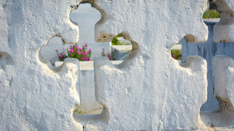 Glimpse through a cut out cross into a cemetery in Colombia