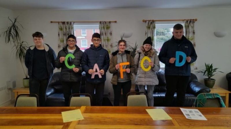 Young people holding up letters to spell the name of the charity CAFOD