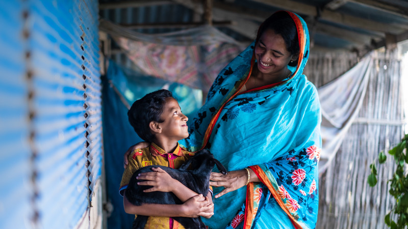 Mother and son holding a baby goat