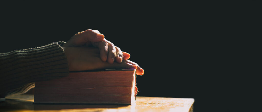 Hands resting on a bible